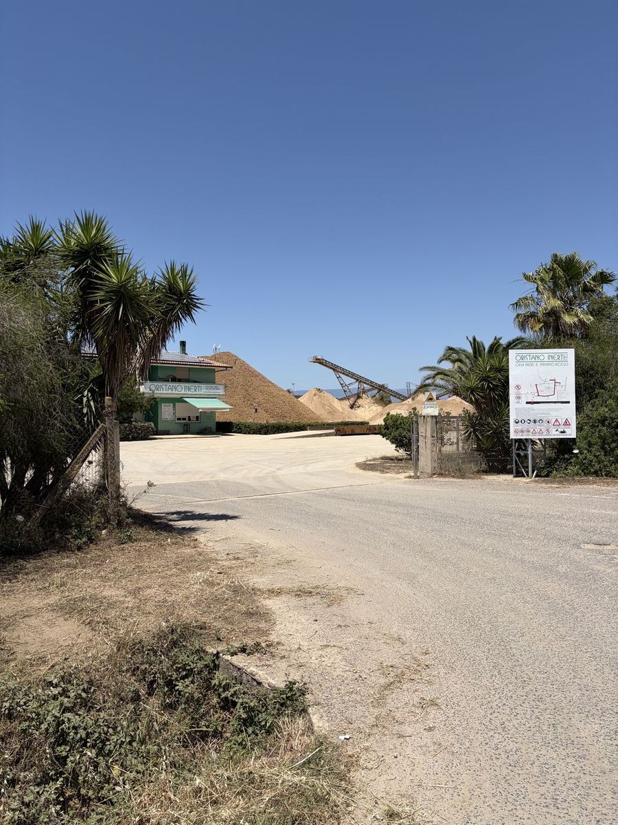 Ingresso della cava Oristano Inerti con cumuli di inerti e nastro trasportatore